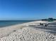 Tranquil beach with white sand and calm, clear turquoise water under a blue sky at 302 Spring Lakes Blvd # 302, Bradenton, FL 34210