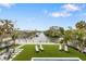 Relaxing backyard oasis with turf grass, lounge chairs, and canal views at 329 Tarpon St, Anna Maria, FL 34216