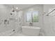 Elegant bathroom featuring a freestanding tub and a frameless glass shower at 329 Tarpon St, Anna Maria, FL 34216