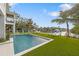 Inviting pool and patio area with artificial turf and lounge chairs, overlooking the canal at 329 Tarpon St, Anna Maria, FL 34216
