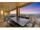 Spacious balcony with outdoor dining furniture and stunning water views at sunset at 35 Watergate Dr # 1203, Sarasota, FL 34236