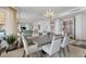 Bright dining room with modern chandelier and seating for six at 35 Watergate Dr # 1203, Sarasota, FL 34236