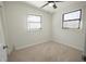 Cozy carpeted bedroom with two windows and neutral walls at 3629 Taro Pl, Sarasota, FL 34232