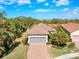 Aerial view of a single-story home with a tile roof, gray garage door, and landscaped yard at 5300 Popoli Way, Sarasota, FL 34238