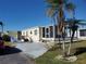 Single-wide yellow manufactured home with a screened porch and palm trees at 5414 Burma Ct, Bradenton, FL 34207