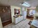 Bright kitchen with white cabinets, granite countertops, and view to living room at 5414 Burma Ct, Bradenton, FL 34207