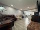 Living room with brown leather furniture, wood floors, recessed lighting, and an open view into the kitchen at 628 Cohen Way # 628, Sarasota, FL 34236