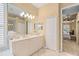 Bright bathroom with a double vanity, tile floors, framed mirror, and access to the main bedroom at 7223 Orchid Island Pl, Bradenton, FL 34202