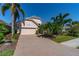 Well-maintained house featuring a paver driveway and tropical landscaping at 7223 Orchid Island Pl, Bradenton, FL 34202
