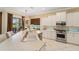 Well-lit kitchen with stainless appliances, white cabinets, tile floors, and a backyard view at 7223 Orchid Island Pl, Bradenton, FL 34202