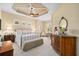 Comfortable main bedroom with tray ceilings, a sitting area, and elegant furnishings at 7223 Orchid Island Pl, Bradenton, FL 34202