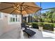 Relaxing patio with umbrella, lounge chair, and view of screened enclosure at 7223 Orchid Island Pl, Bradenton, FL 34202