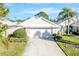 Single-story house with white exterior, two-car garage, and manicured lawn at 805 Harrington Lake N Dr # 76, Venice, FL 34293