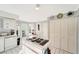Kitchen with island, white cabinetry, and built-in appliances at 805 Harrington Lake N Dr # 76, Venice, FL 34293