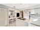 White kitchen with island cooktop and built-in appliances at 805 Harrington Lake N Dr # 76, Venice, FL 34293