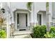 Townhome's front entrance with gray door, stone accents, and landscaping at 8608 Stargazer St, Sarasota, FL 34238