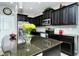 Modern kitchen with dark cabinetry, granite counters, and stainless steel appliances at 8608 Stargazer St, Sarasota, FL 34238