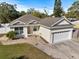 Single-story house with a beige exterior, white garage door, and a well-maintained lawn at 8742 Filson Pl, Sarasota, FL 34231