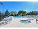 Inviting pool area with a spa, lounge chairs, and tables with umbrellas at 8753 Pebble Creek Ln, Sarasota, FL 34238