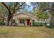 Charming single-story home with red front door and covered porch nestled among mature trees at 11866 Northtrail Ave # 11866, Temple Terrace, FL 33617