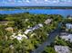 Scenic aerial view showing waterfront homes nestled along a canal leading to a larger body of water at 1214 Sea Plume Way, Sarasota, FL 34242