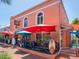 Pastel pink building with outdoor seating and umbrellas at 1214 Sea Plume Way, Sarasota, FL 34242