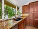 Kitchen with granite countertops, double sink, and wooden cabinets at 1214 Sea Plume Way, Sarasota, FL 34242