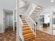 Modern white staircase with wood steps and tile flooring at 1214 Sea Plume Way, Sarasota, FL 34242