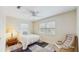 Bedroom with ceiling fan, window, bedside table, comfortable chair, and area rug at 1220 26Th W St, Bradenton, FL 34205