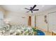 Fifth bedroom with double doors, palm-leaf bedding, ceiling fan, and attached bathroom at 1220 26Th W St, Bradenton, FL 34205
