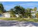 Single-story home with a paved driveway, attached two-car garage, and tropical landscaping at 1220 26Th W St, Bradenton, FL 34205