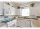 White kitchen with granite countertops and microwave at 24181 Green Heron Dr # 84, Punta Gorda, FL 33980