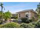 Side view showcasing the home's light beige exterior and landscaping at 322 Avenida De Paradisio, Sarasota, FL 34242
