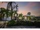 Single-story home with palm trees, lush landscaping, and a two-car garage at 322 Avenida De Paradisio, Sarasota, FL 34242