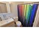 Bathroom with a rainbow shower curtain and white vanity at 3310 Lexington St, Sarasota, FL 34231
