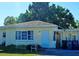 House with a carport and a large tree in front at 3310 Lexington St, Sarasota, FL 34231