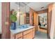 Bathroom with light blue tile, wood vanity, and a view to the bedroom at 3348 Old Oak Dr, Sarasota, FL 34239