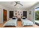 Bright bedroom with two twin beds, artwork, and sliding glass doors to the outdoors at 3348 Old Oak Dr, Sarasota, FL 34239