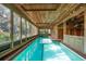 Long indoor pool with brick surround and large windows offering natural light at 3348 Old Oak Dr, Sarasota, FL 34239