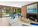 Cozy living room with a fireplace, comfortable seating, and large windows overlooking the greenery at 3348 Old Oak Dr, Sarasota, FL 34239