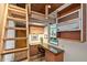 Compact home office with built-in desk, shelving, and a ladder leading to a loft at 3348 Old Oak Dr, Sarasota, FL 34239