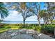 Enjoy the beautiful waterfront view from the patio with comfortable seating and beautiful trees at 3350 Old Oak Dr, Sarasota, FL 34239