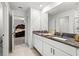 Dual vanity bathroom with granite counters, white cabinets, and a view of the bedroom at 4016 86Th E St, Palmetto, FL 34221