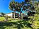 Exterior view of a home with a screened-in lanai, lush landscaping, and palm trees at 5245 88Th E St, Bradenton, FL 34211