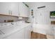 Laundry room with white cabinets, washer, and dryer at 5706 Bent Oak Dr, Sarasota, FL 34232