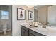 Double vanity bathroom with a window, good lighting, and neutral tones at 6912 Prairie Oak Way, Nokomis, FL 34275