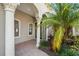 Elegant front entrance with decorative columns, lush tropical foliage, and charming architectural details at 7134 Westhill Ct, Lakewood Ranch, FL 34202