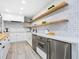 White kitchen with wood shelving and subway tile at 749 Tropical Cir, Sarasota, FL 34242