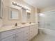 Bathroom featuring a double sink vanity, tub/shower combo with glass doors, and vanity mirror at 850 S Tamiami Trl # 227, Sarasota, FL 34236
