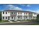 Three-unit townhome building with light gray siding and teal doors at 8944 Daybreak St, Sarasota, FL 34241